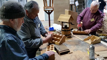 Photo showing several shed members constructing spice racks